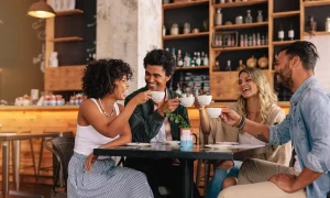 Friends at a table drinking coffee and laughing