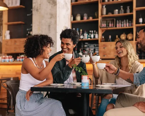 Friends at a table drinking coffee and laughing